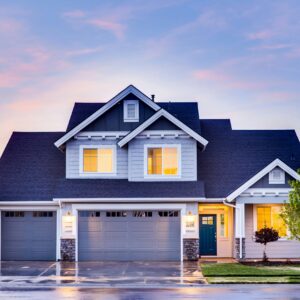 Beautiful two-story house with illuminated windows and garage at dusk.